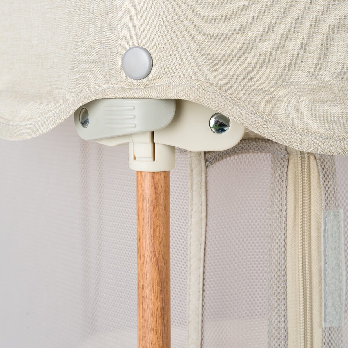 Close-up of the Hexa playpen locking joint in ecru, highlighting the secure frame connection and wooden leg detail