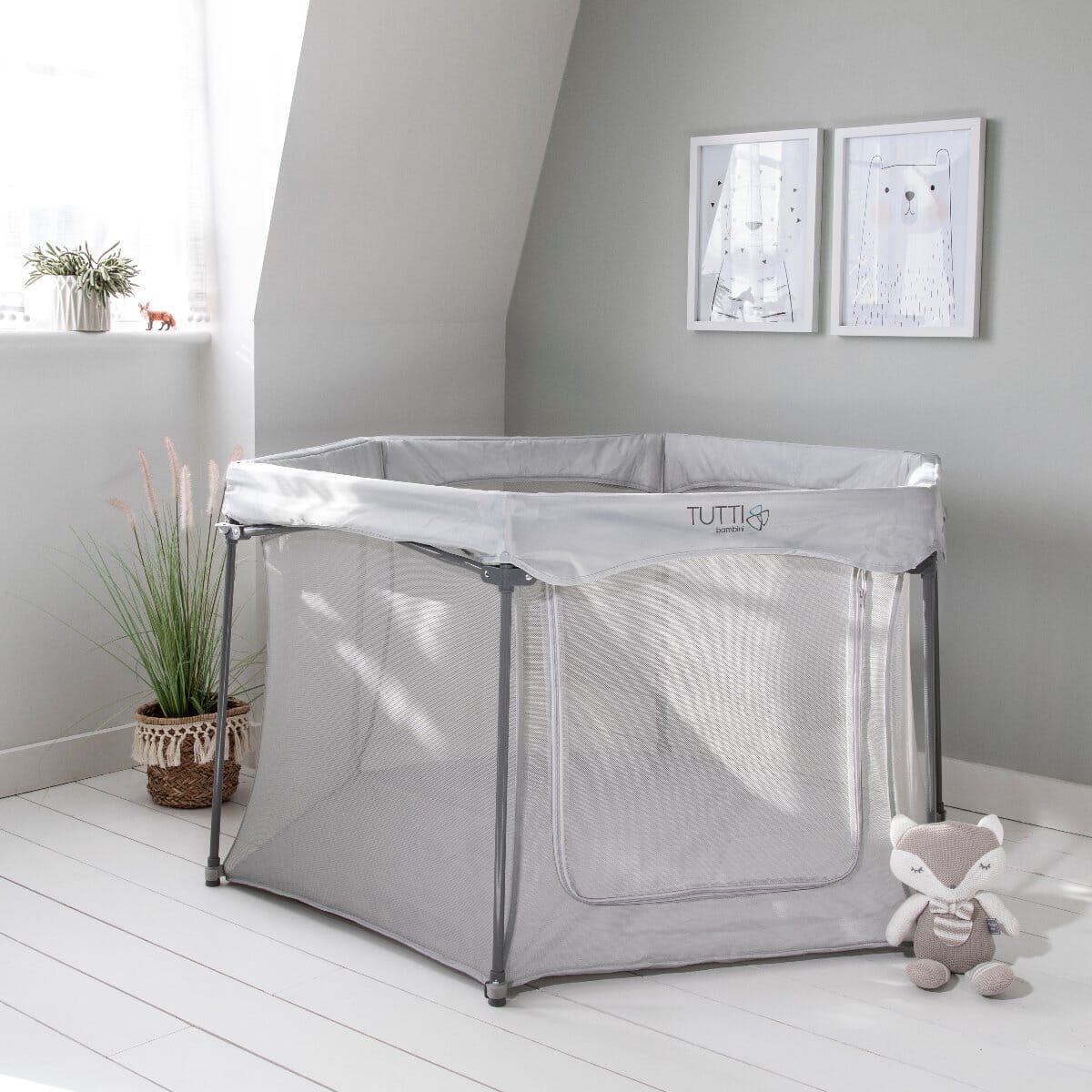 Lifestyle view of the grey Hexa playpen in a bright nursery, showing mesh sides and zip door for safe, visible supervised play
