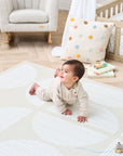 baby smiling and crawling on the infinity baby playmat in orbital oatmeal