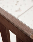 Japandi cot bed in warm walnut close-up of the protective teething rail, made from clear, chew-safe material to protect delicate gums and the wood finish.