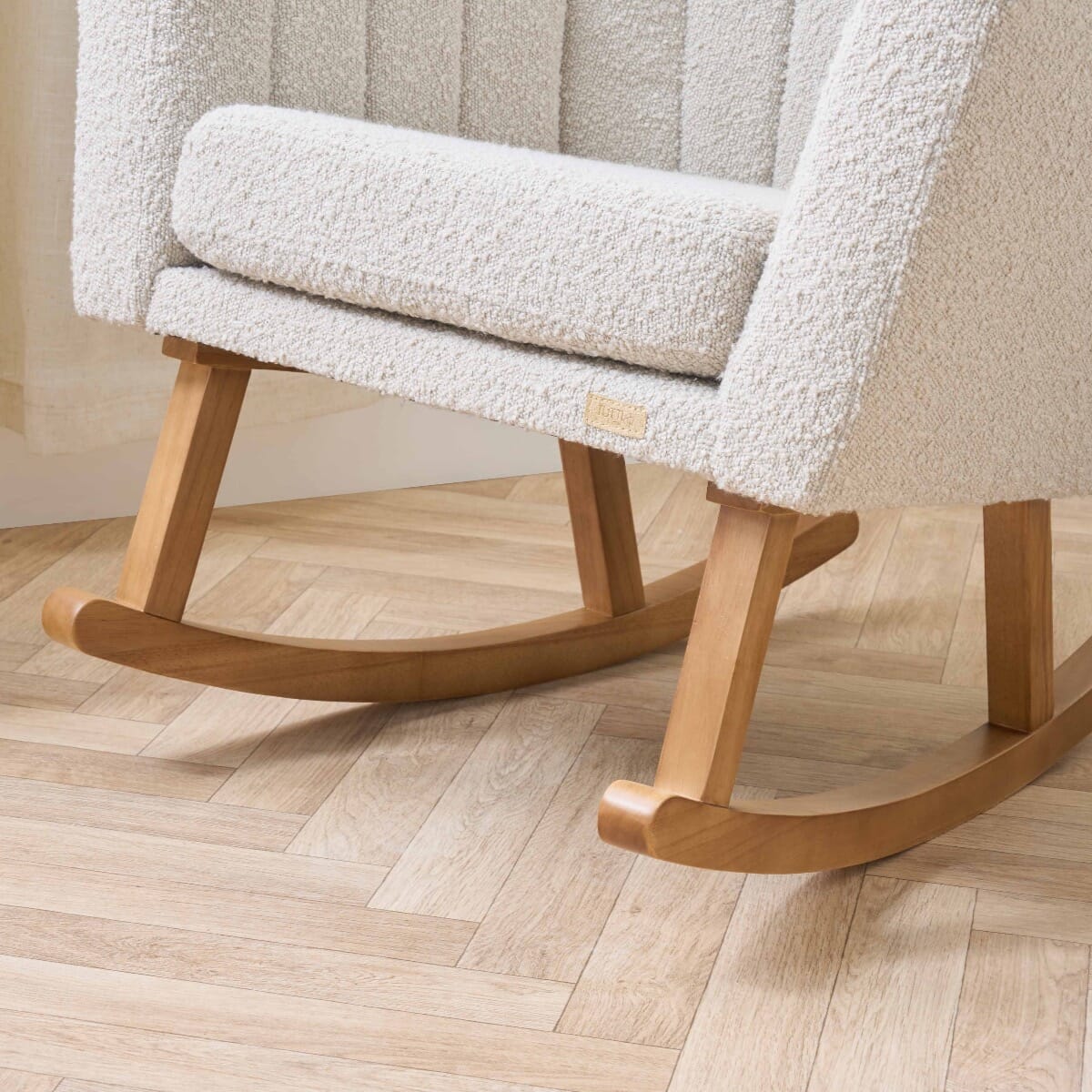 Close-up of the Jonah Luxe rocking chair and footstool in boucle mushroom, highlighting the natural wood rockers and textured upholstery