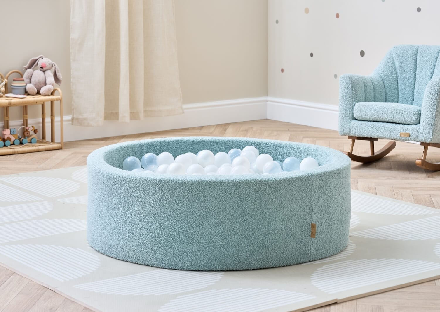 Bola baby ball pit in ocean stone styled in a calm nursery setting, filled with soft white balls for gentle, everyday play