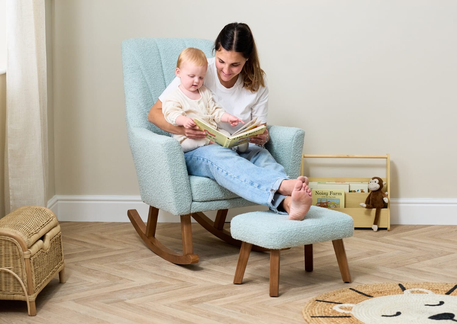 Parent and baby reading together in the Jonah Luxe rocking chair and footstool in boucle ocean stone, creating a calm bonding moment