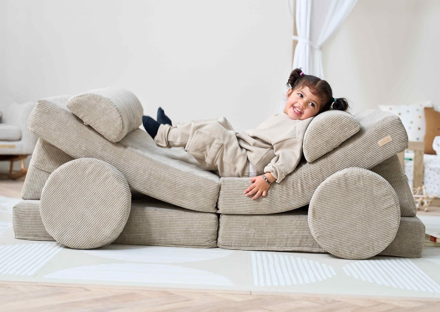 Child relaxing on the Playrama kids play sofa in mushroom, arranged as a lounger to highlight comfort, flexibility and imaginative play
