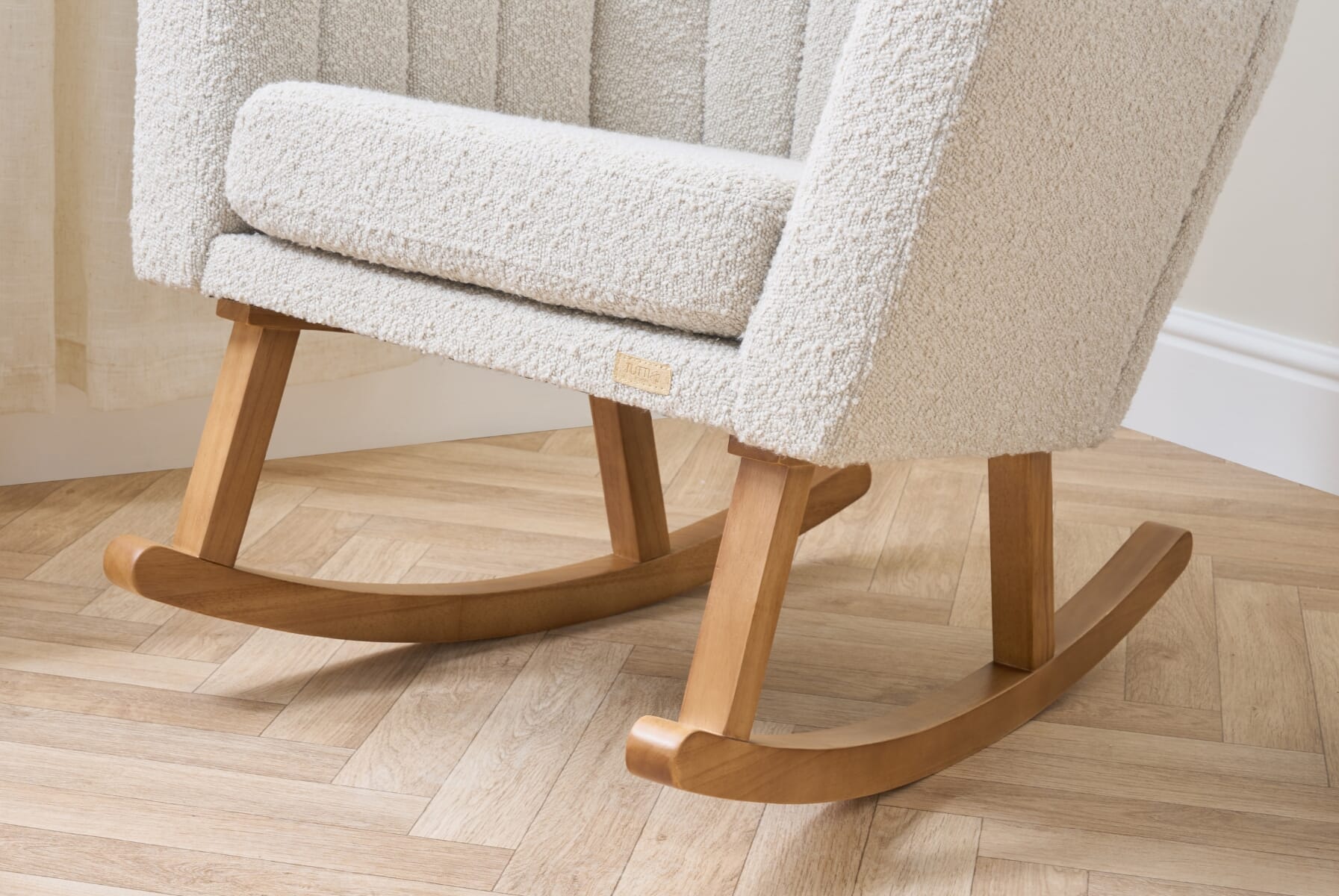 Close-up of the Jonah Luxe rocking chair base in natural wood, showing smooth curved rockers designed for gentle, stable movement