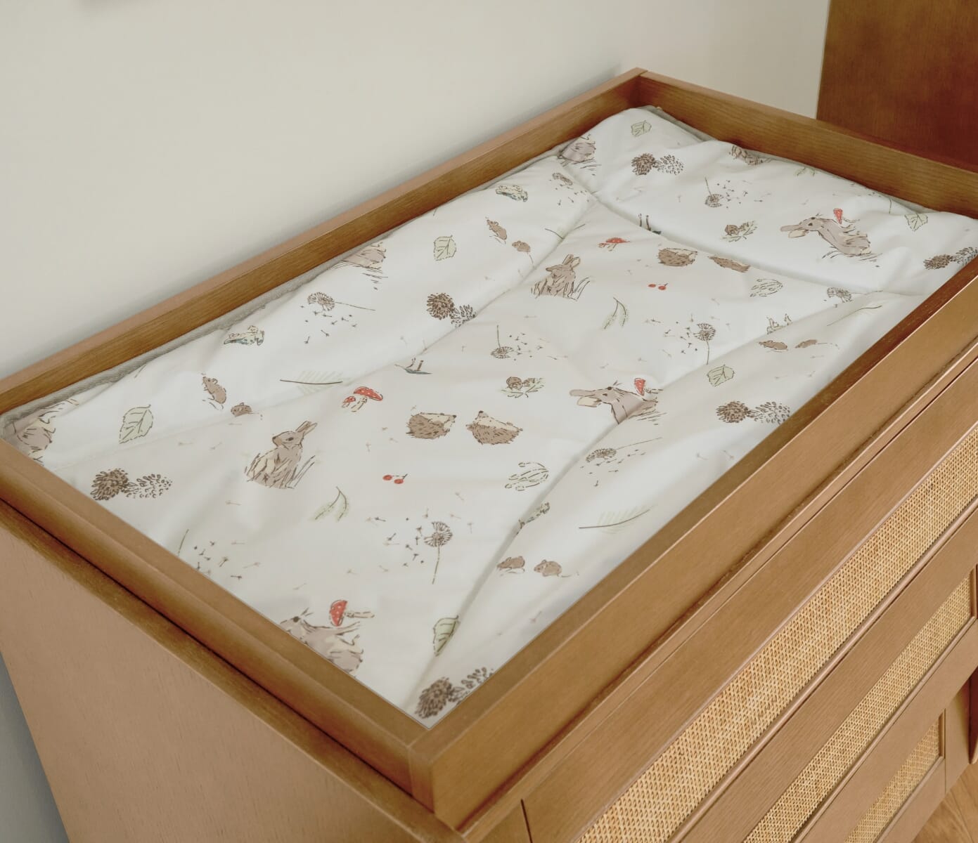 Close-up view of the Japandi Chest of drawer in light oak with a removable changing top and the Woodland changing mat, offering versatile functionality as your child grows.