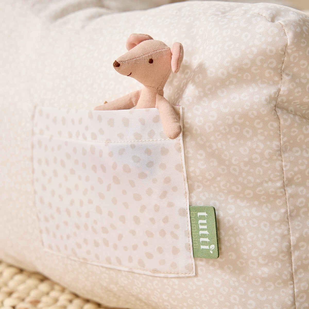 Close-up of the Luca Leopard beanbag chair with soft toy in side pocket, highlighting subtle print fabric and Tutti Bambini brand tag