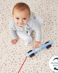 Baby sits on the terrazzo side of the reversible play mat, its cushioned surface offering a comfy, patterned area for early play