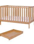 Cutout view of the Malmo cot bed and matching cot top changer in warm oak finish, highlighting coordinated design and easy fit