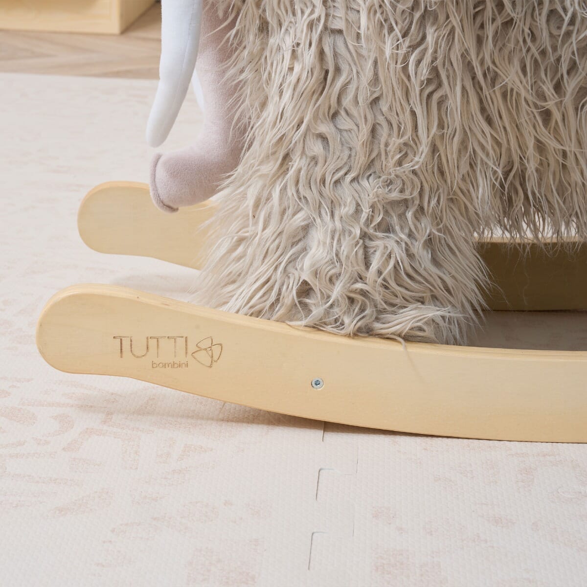 Close-up side view of Mimi the Mammoth rocking toy, focusing on smooth wooden rockers and stable base for safe indoor play