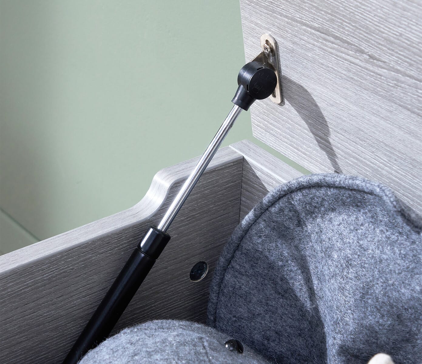 Close-up of the Modena toy box in grey ash showing the soft-close hinge mechanism for safer, quieter opening during playtime