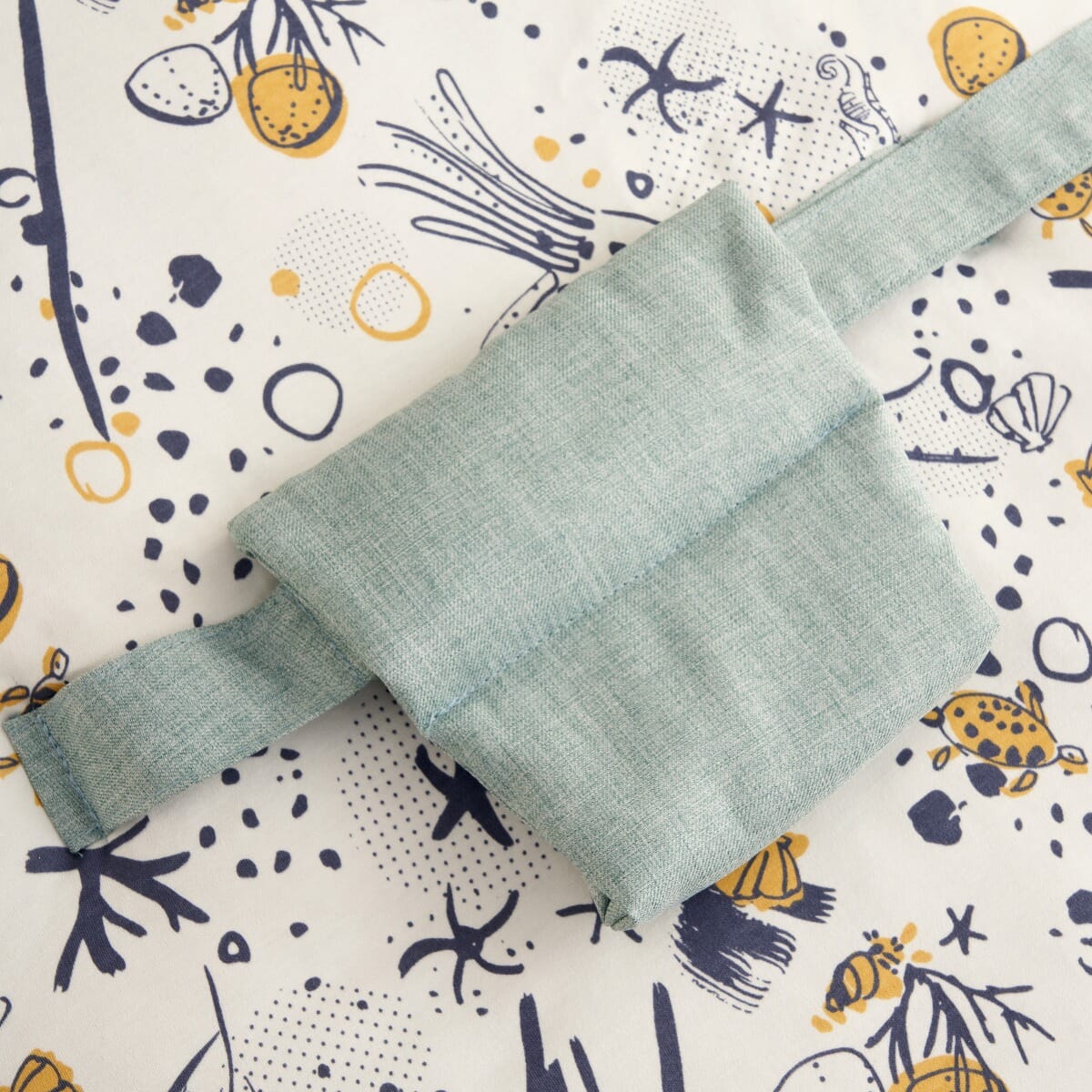 Detailed view of the Our Planet baby beanbag safety strap in soft woven fabric, highlighting the adjustable design for a snug, supportive fit