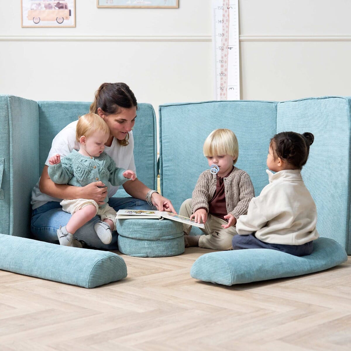 Group view of the Playrama Montessori Kids Play Sofa in ocean stone, with a mother and toddlers reading together in a cosy play setup