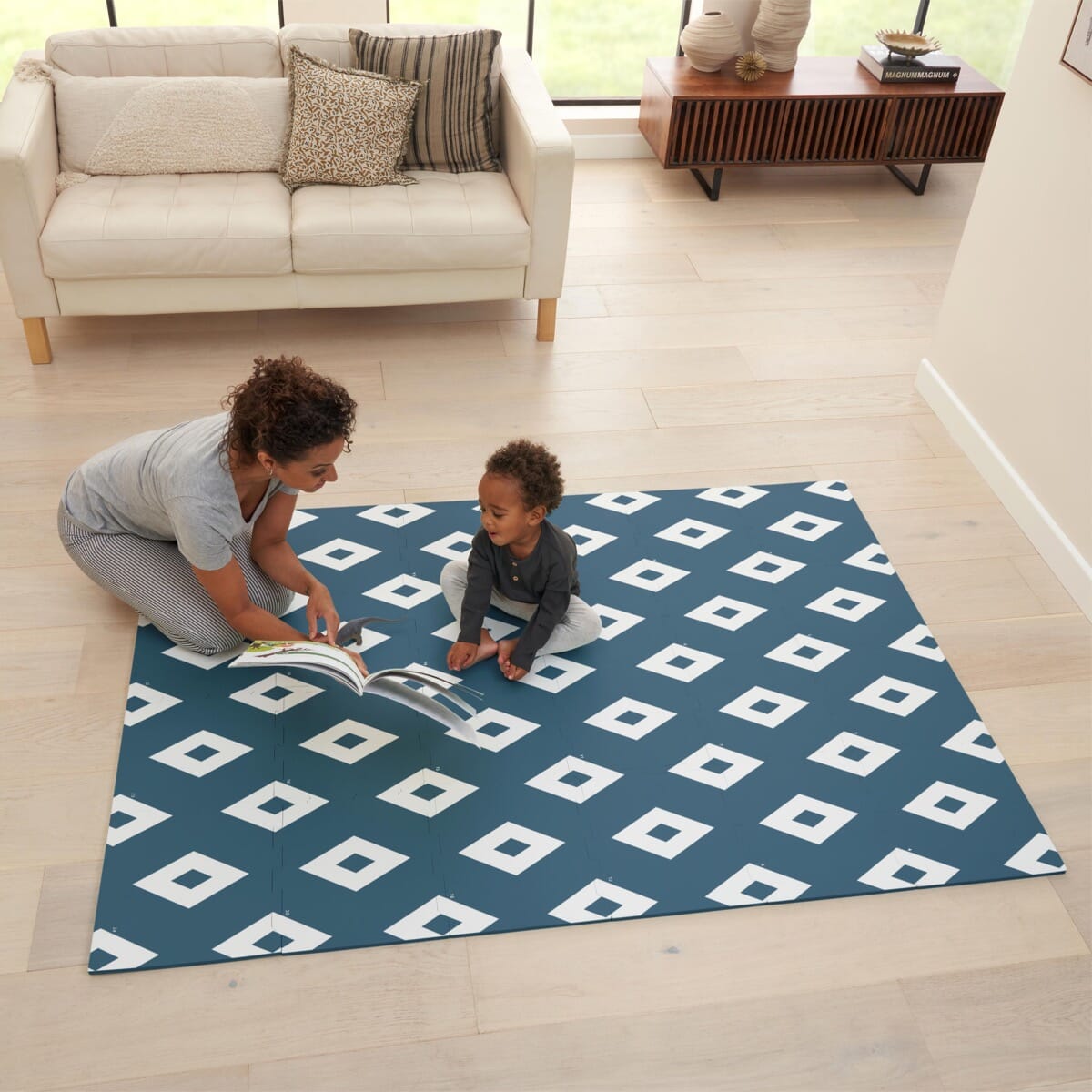 Lifestyle image of the diamond deep ocean puzzle playmat, with parent and child enjoying quiet play on the padded surface