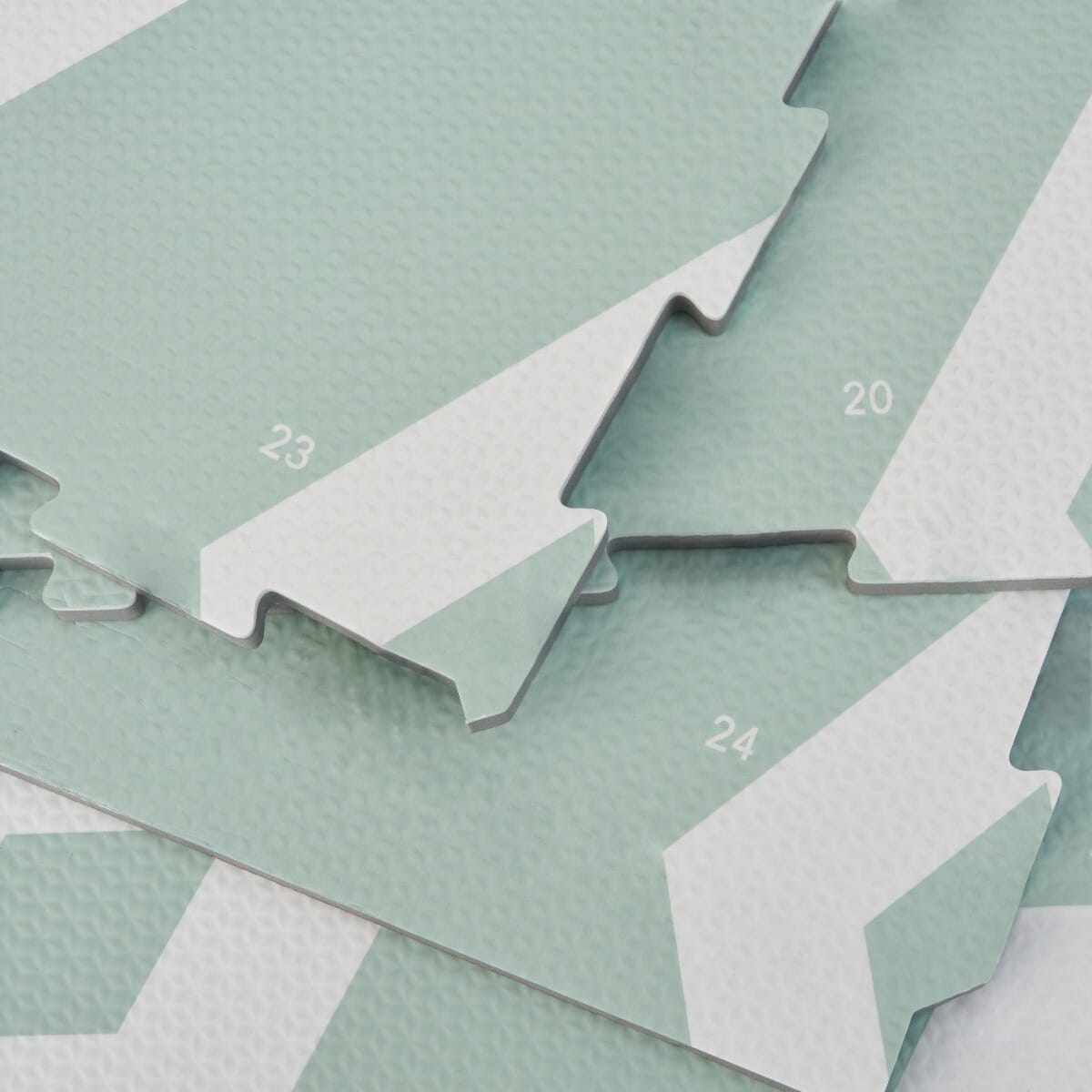 Close-up of Diamond Mint puzzle playmat tiles with numbered edges and textured surface, highlighting its interlocking design
