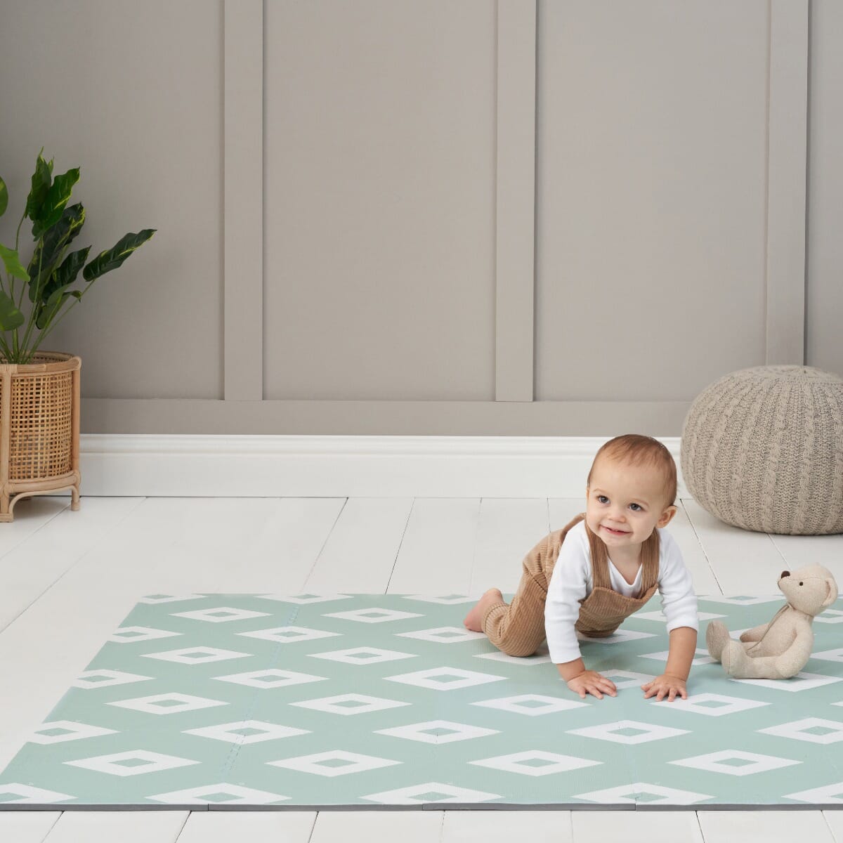 Toddler crawling on the Diamond Mint puzzle playmat in a bright room, enjoying a soft, cushioned surface with a modern geometric pattern