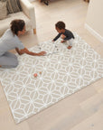 Lifestyle scene showing parent and child playing on the tiles white sand puzzle playmat, offering cushioned comfort for floor play