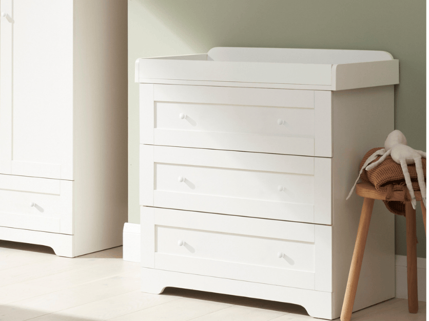 Angled lifestyle view of the Rio chest changer in white, featuring three spacious drawers and a clean, timeless nursery look