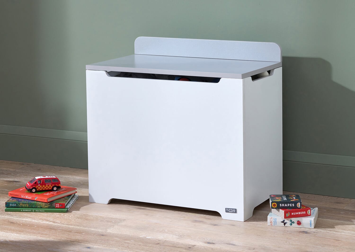 Lifestyle view of the Rio toy box in white and dove grey with lid closed, showing clean lines, soft edges and a practical design for toy storage