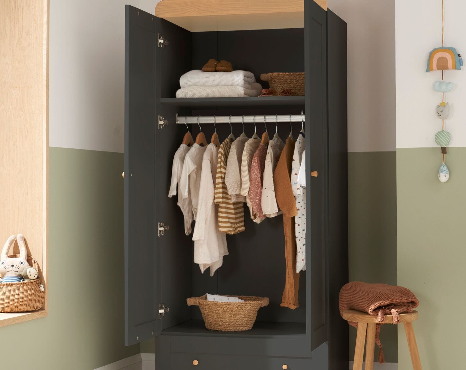 Rio wardrobe in slate grey and honey oak with doors open, showing hanging space, shelf storage, and neatly arranged baby clothes