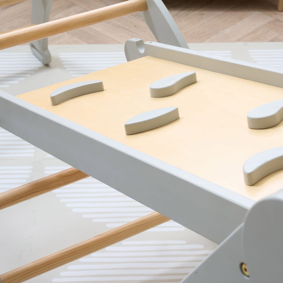 Detail of the Scala Montessori Pikler climbing wall in mushroom finish with wooden grips, supporting balance and motor skill practice