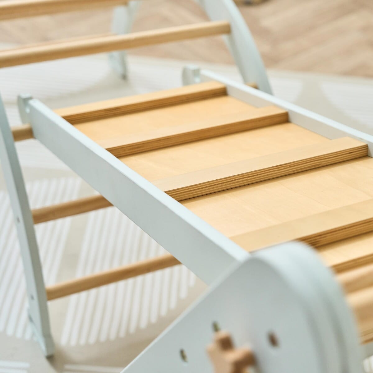 Close-up of the Scala Montessori Pikler wall ladder in sea mist, highlighting the smooth wooden rungs and durable construction