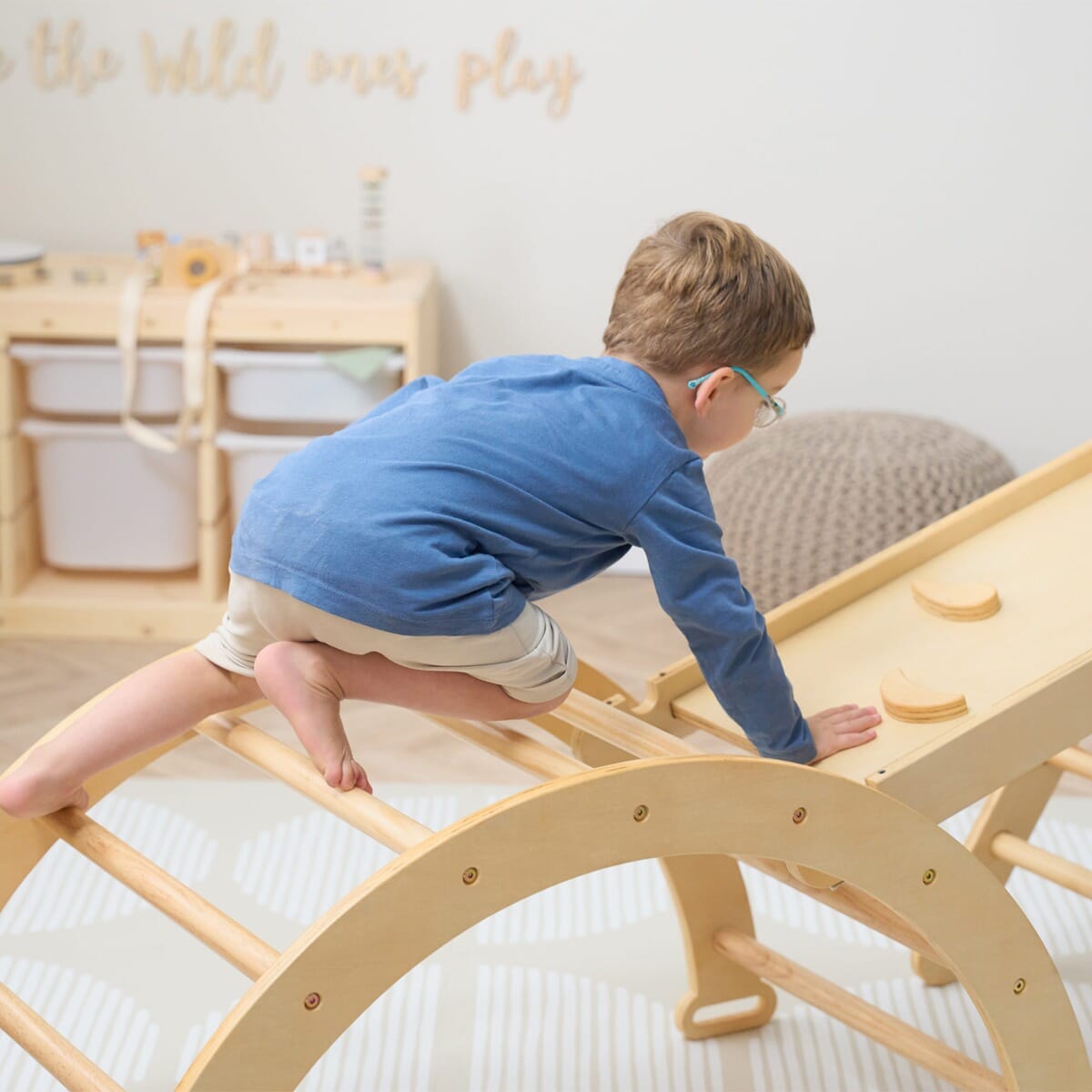 Young child climbing the Scala Montessori Pikler climbing frame in natural finish, encouraging balance, grip, and confident movement