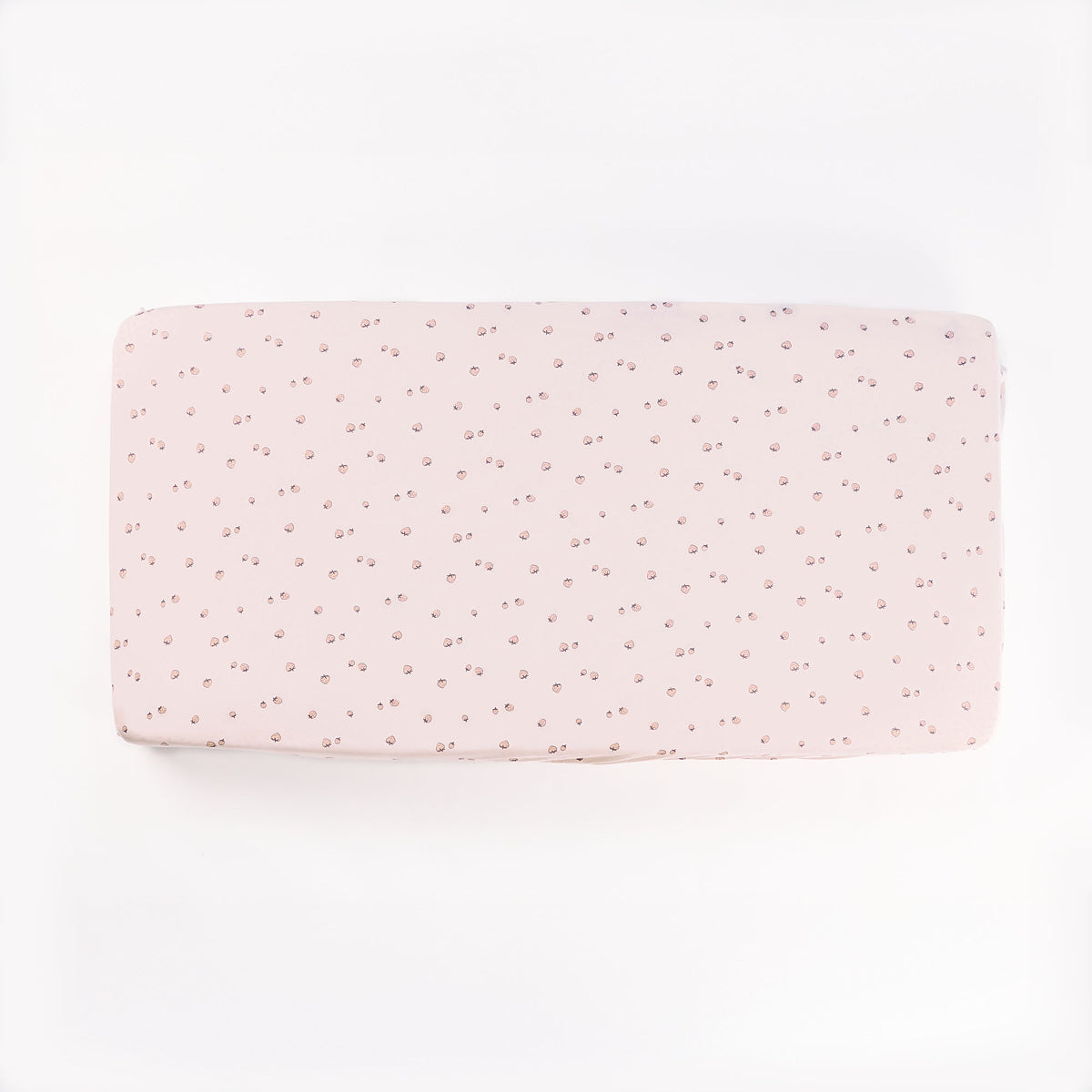 Cutout of Tiny Tails cot fitted sheet in soft pink featuring a strawberry motif pattern, made from smooth, gentle cotton fabric