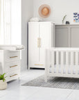 Tivoli white 3-piece nursery set for children, including a cot, a chest of drawers with a changing table on top, and a wardrobe, placed in a room with a grey floor and walls.