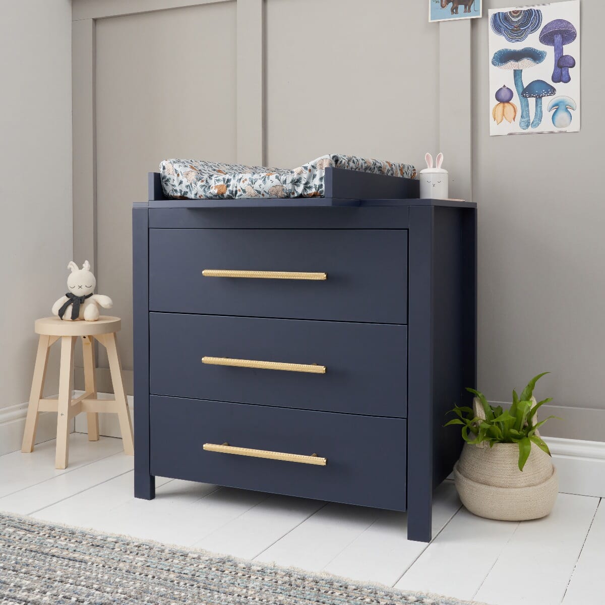 Chest changer in navy with matching changing top attached, showing generous drawer storage and soft gold handles for a refined nursery look