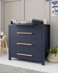 Chest changer in navy with matching changing top attached, showing generous drawer storage and soft gold handles for a refined nursery look