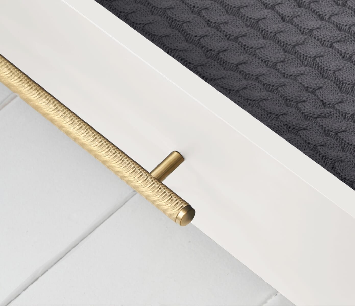 Close-up view of the Tivoli chest changer in white, highlighting the textured gold handle detail and smooth painted finish beneath the changing top