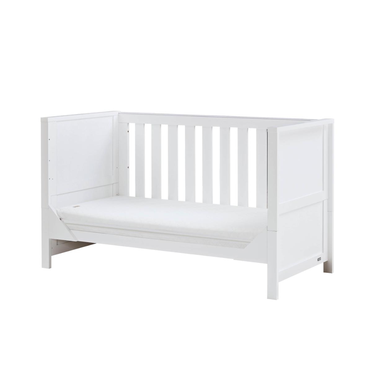 Angled view of the Tivoli cot bed in white in sofa bed mode, highlighting open sides and supportive base for daytime lounging