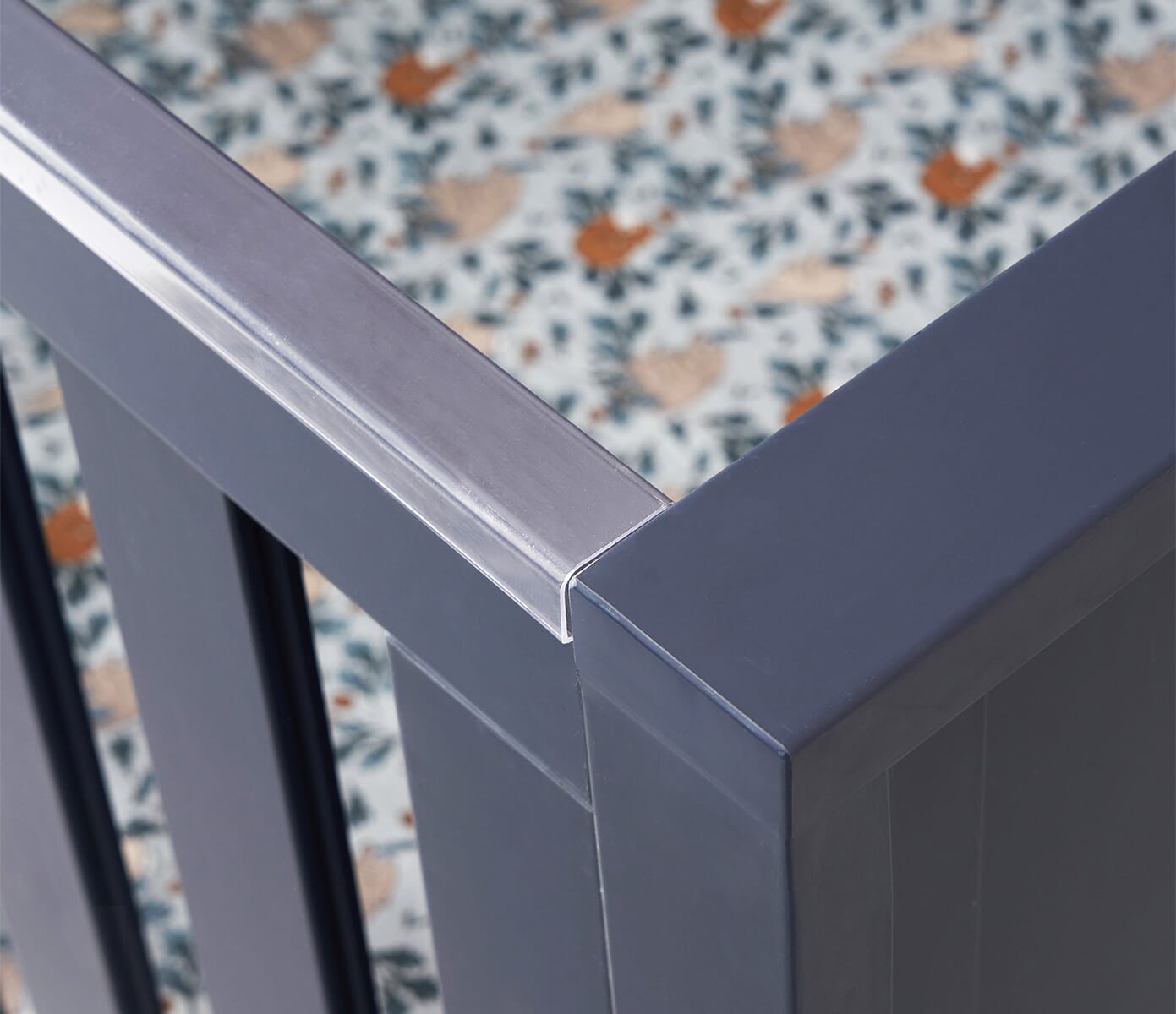 Close-up of the Tivoli cot bed’s navy teething rail, showing its smooth protective cover designed to support little ones safely