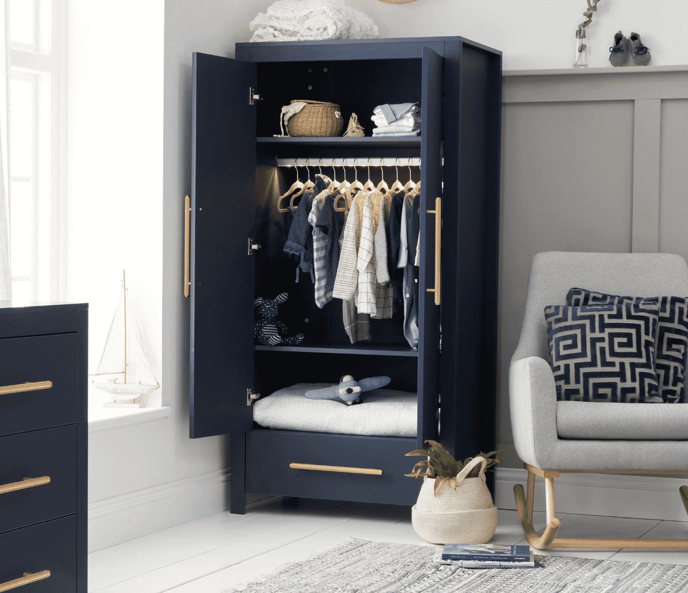 Open wardrobe view of the Tivoli design in navy, showing dual rails, shelves and storage space arranged with children’s clothes and soft accessories