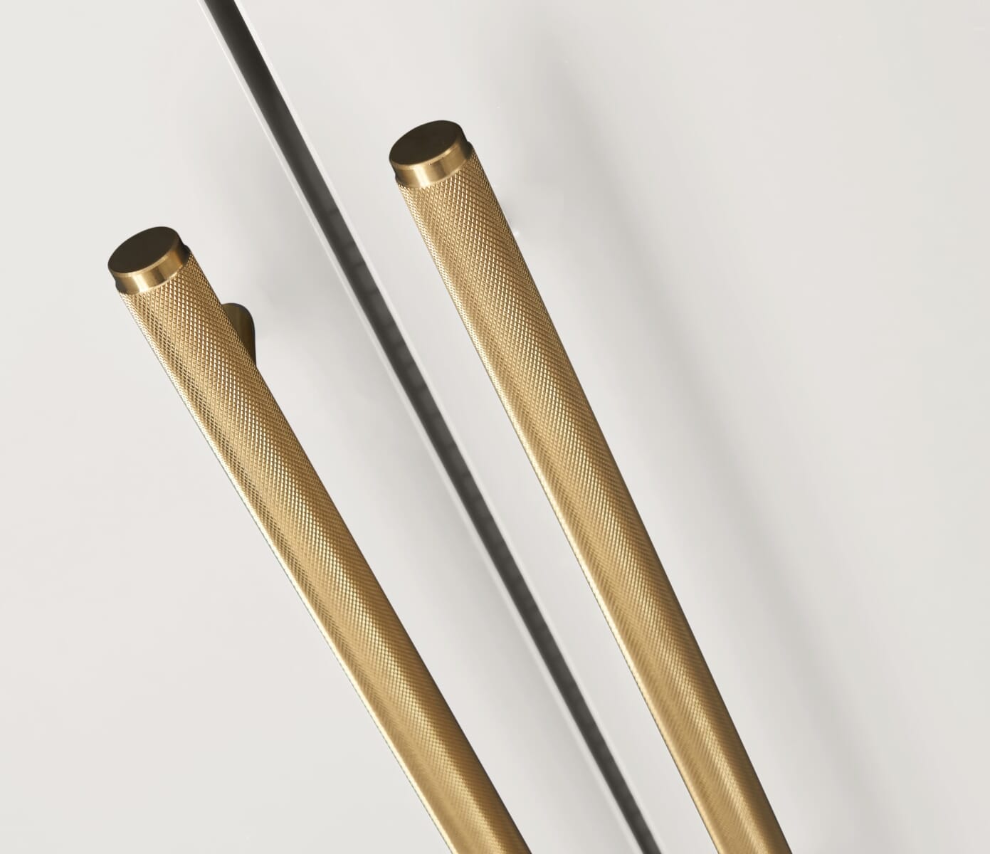 Close-up view of the Tivoli wardrobe in white, focusing on textured gold handles and clean door lines against a smooth painted finish