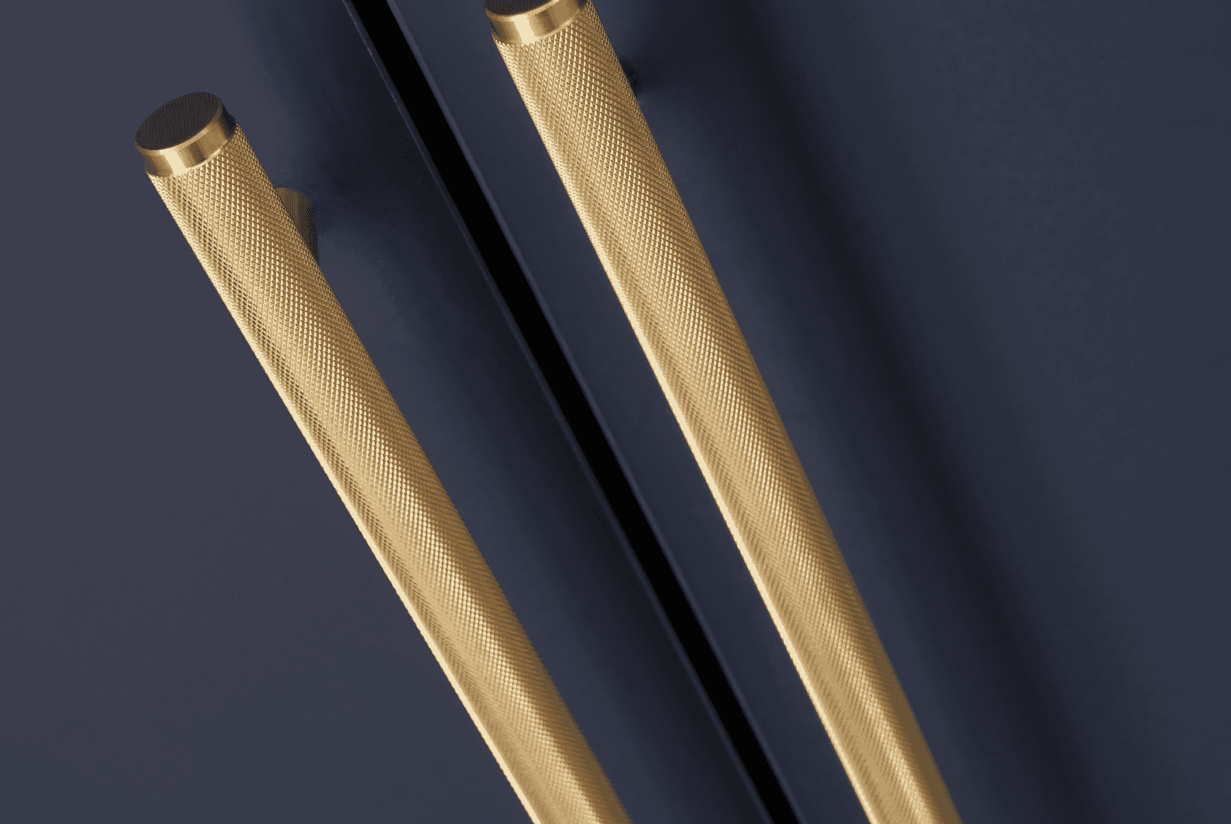 Detailed close-up of the Tivoli wardrobe’s textured gold handles against the navy finish, highlighting refined craftsmanship and modern contrast