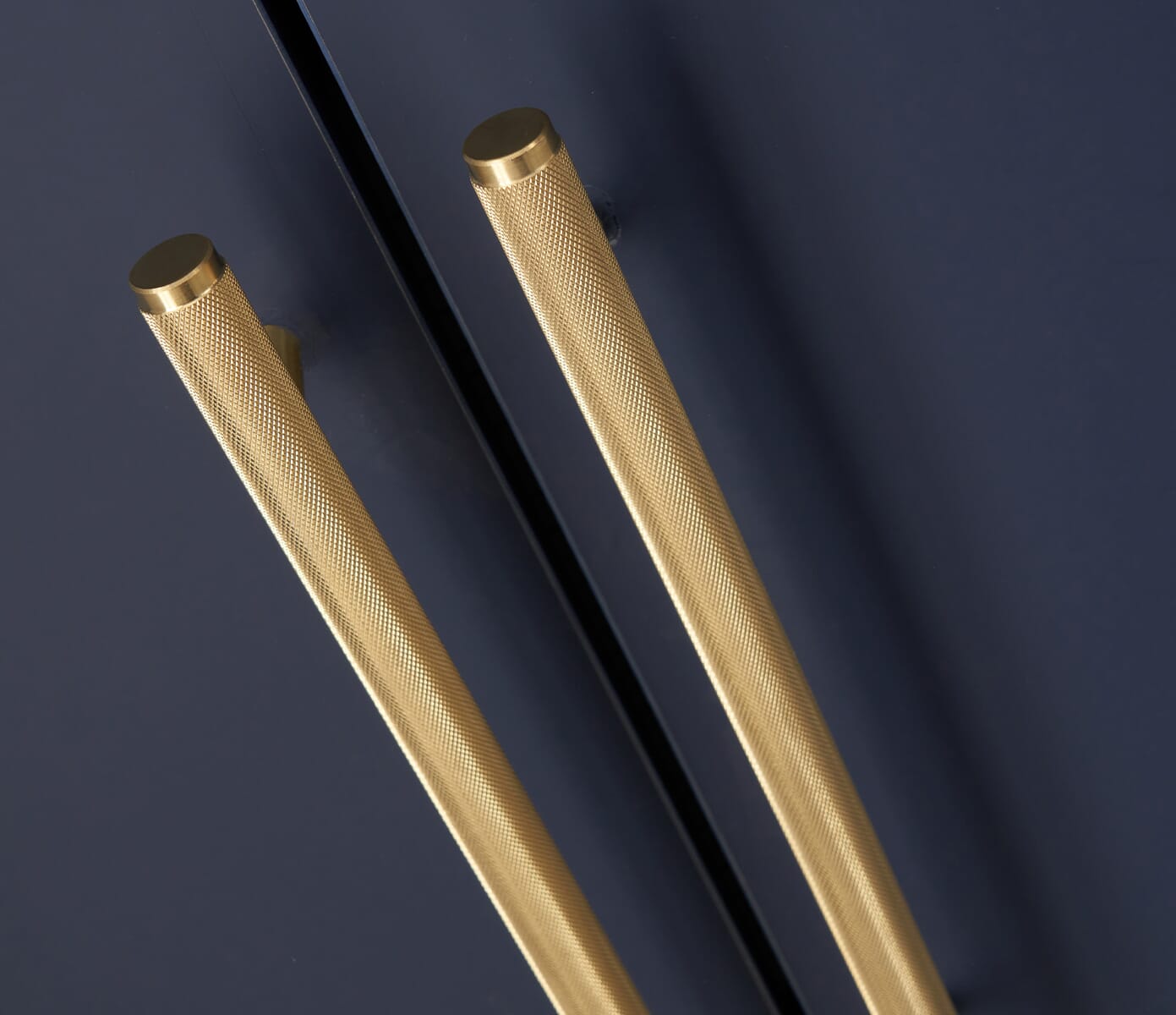 Close-up of the Tivoli wardrobe’s textured gold handles against a navy finish, highlighting the sleek, modern detailing and quality craftsmanship