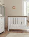 Verona cot bed with chest changer in white and oak, demonstrating the integrated changing top and deep drawers for organised nursery storage.