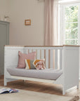 Verona cot bed converted to a day sofa bed with pillows, demonstrating multi-use functionality for growing children