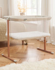 A ZiZee Breathable Rocking Crib with Scandinavian Walnut and Ecru finish, featuring an all-around mesh and wheels for mobility.